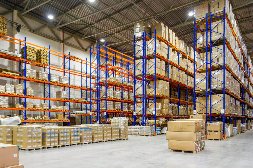 Interior of a modern warehouse storage of retail shop with pallet truck near shelves